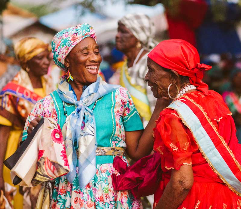 Haitian women – Photo: Kolektif 2 Dimansyon Four laughing Haitian women in traditional costume